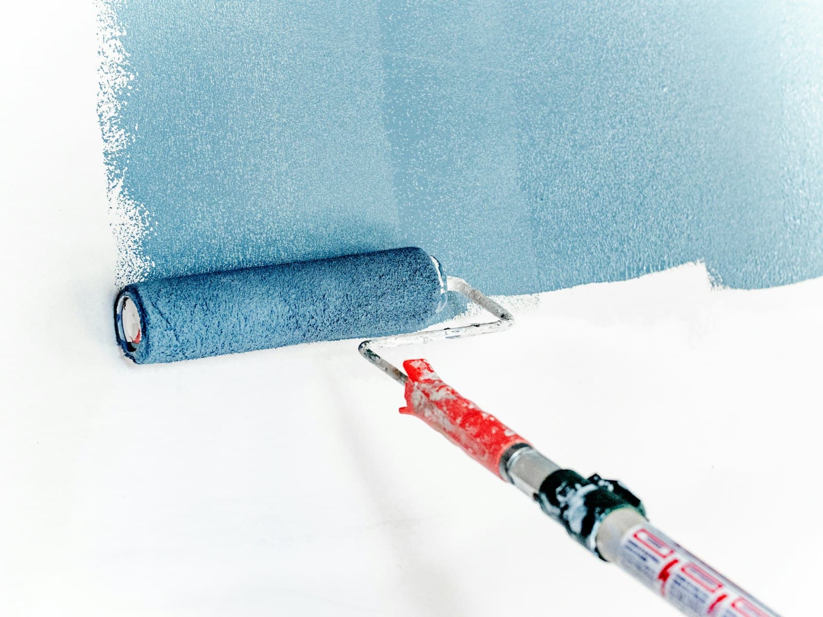 Rouleau de peinture jaune sur un mur, photo d'illustration